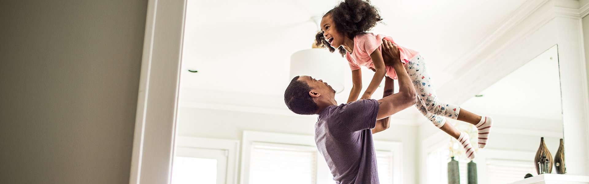 Man lifting a child in the air over his head