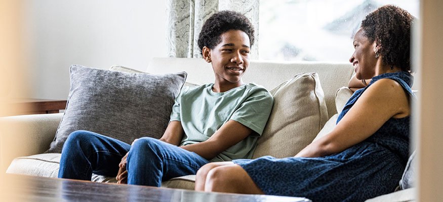 mom and son at home on couch talking