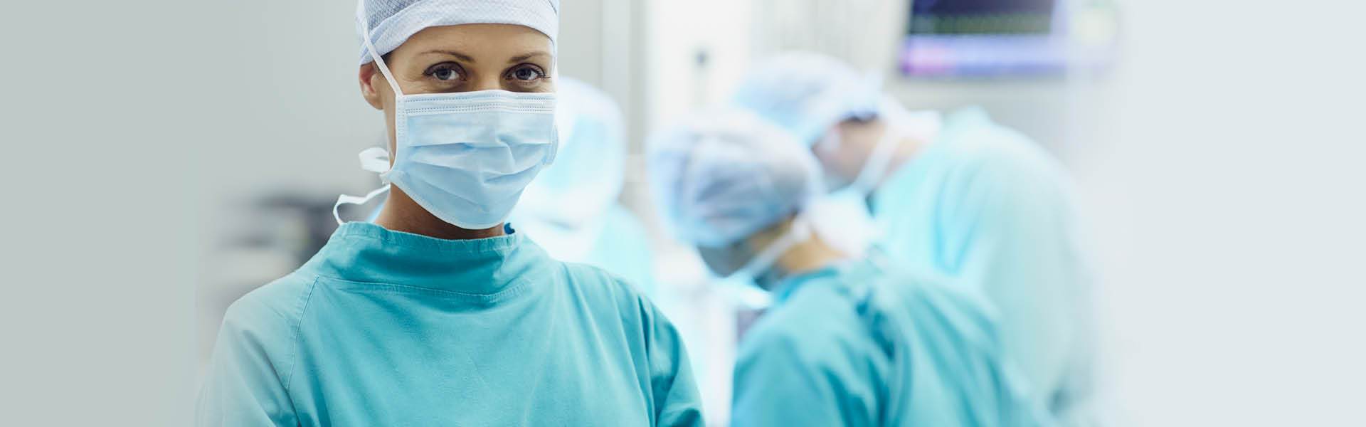 surgeon wearing a mask looking at the camera.