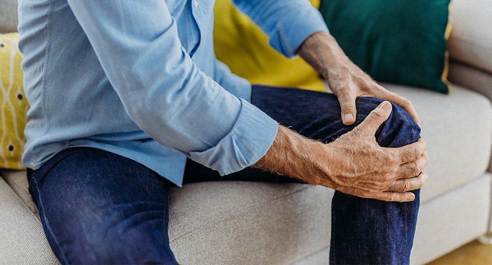 man holding knee close-up