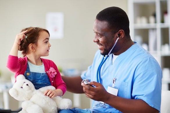 A young girl attentively sits in front of a doctor, engaged in a conversation about her health.