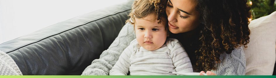 woman holding child on couch