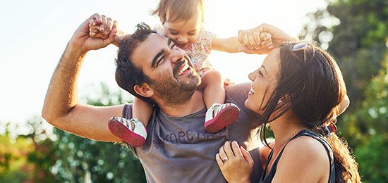 family smiling outdoors