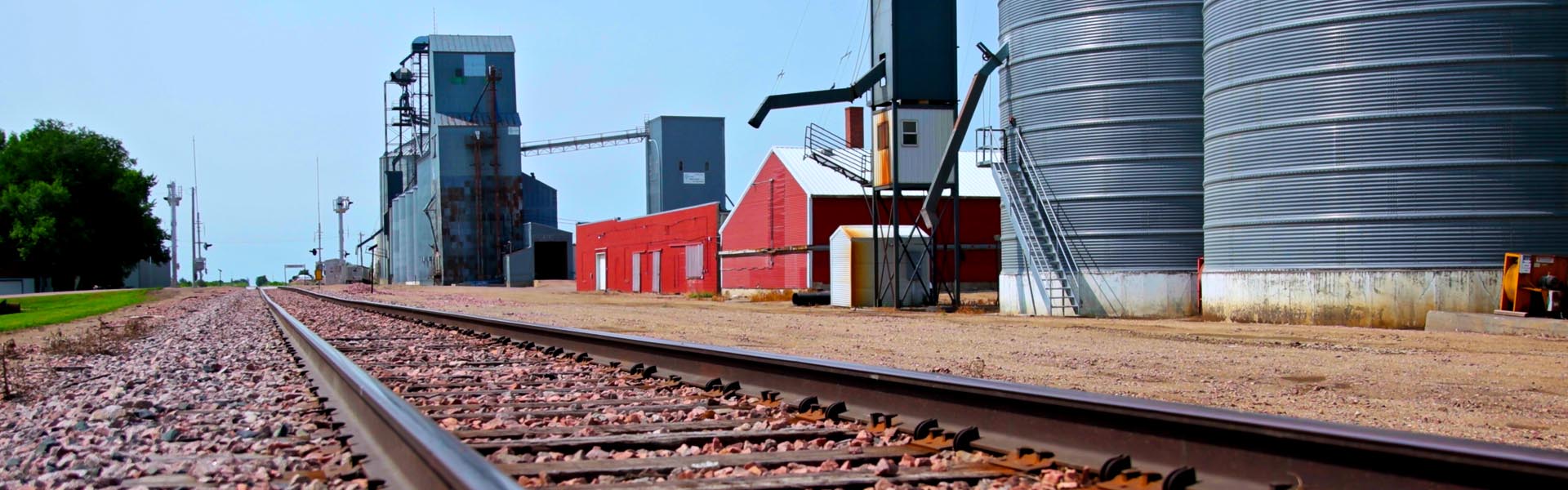 Rural community showing grain elevator, silos and railroad tracks.