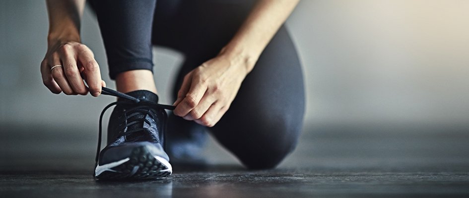 athlete woman tying black shows kneeling