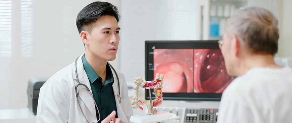 doctor showing colon model to patient.