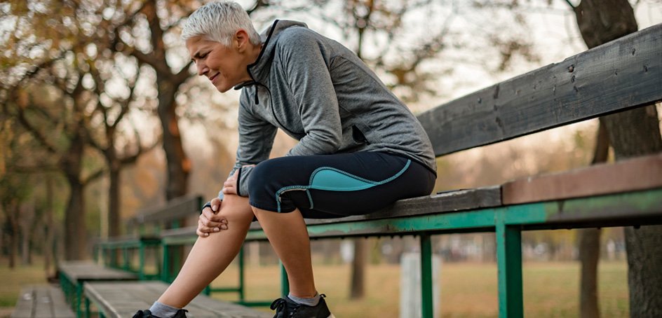 Woman holding sore knee.