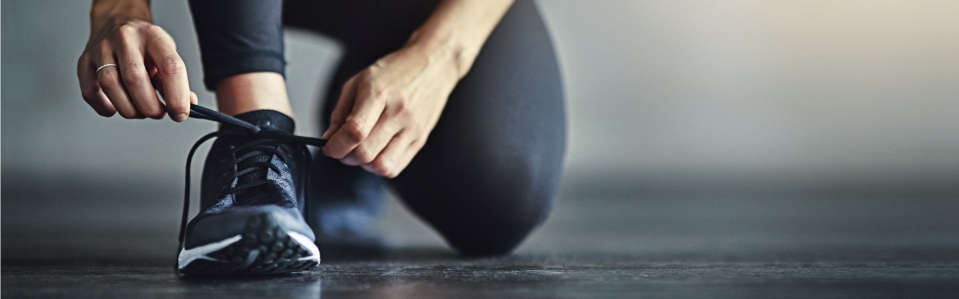 Woman tying her shoe for a sports activity.