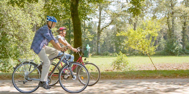 couple riding bike in a park.